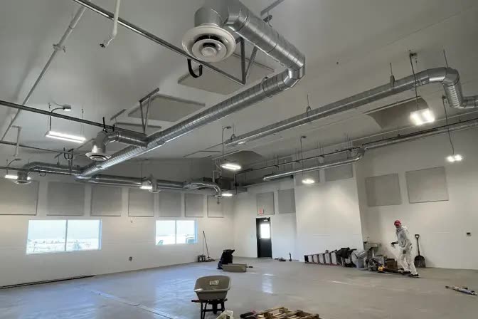 Open commercial interior with exposed conduit and lighting