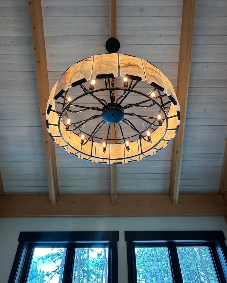 Round chandelier hung from a vaulted wood ceiling